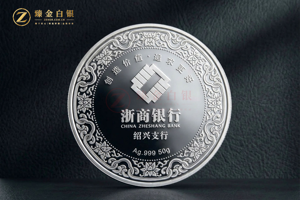 银行纪念银章正面：镜面底上的行徽、中英文行名与缠枝莲花纹装饰环